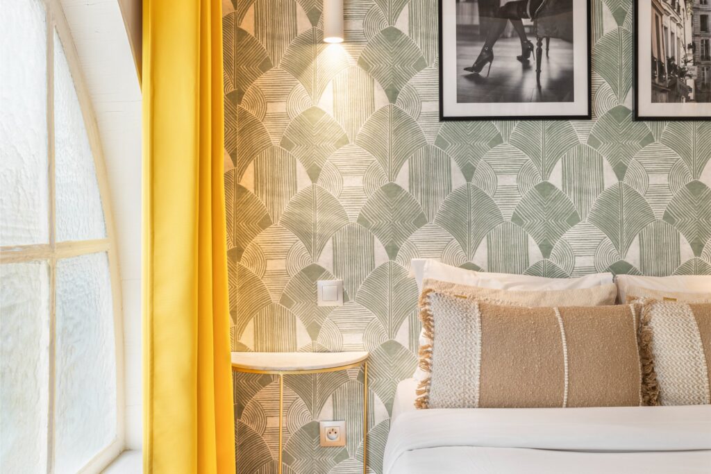 Chambre d’hôtel élégante avec lit et fenêtre lumineuse.
